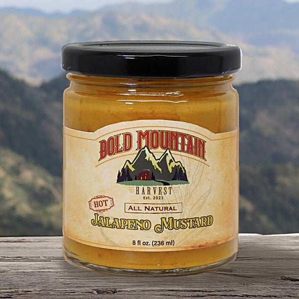 Bold Mountain Harvest Jalepeno Mustard in and 8-ounce jar in front of a mountain view. The mustard is marked with the word hot.