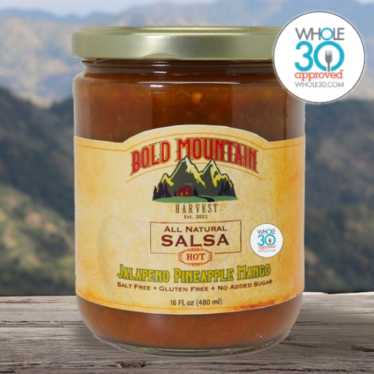 A 16-ounce jar of Jalepeno Pineapple Mango Salsa from Bold Mountain Harvest. The salsa is marked Hot and is Whole 30 Approved.